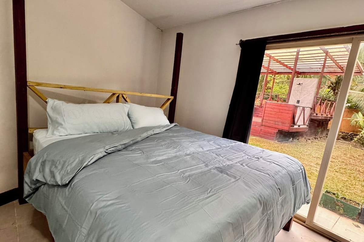 Un dormitorio con cama, ventana y vistas al exterior.