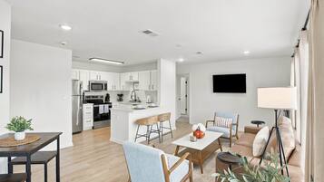 A modern apartment with a kitchen, dining area, and living room.