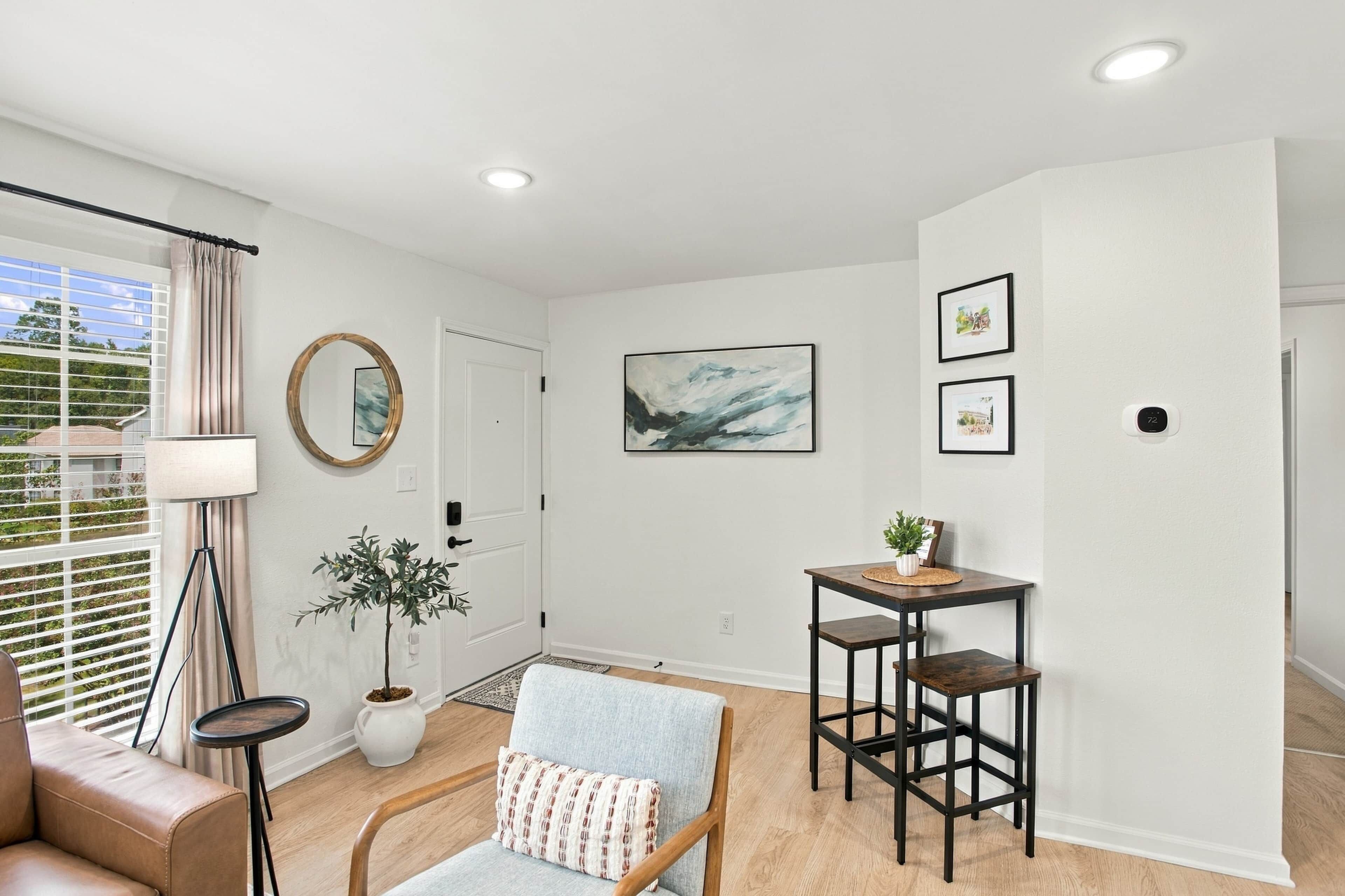 A modern living room with a sofa, a chair, a small table, and a potted plant.