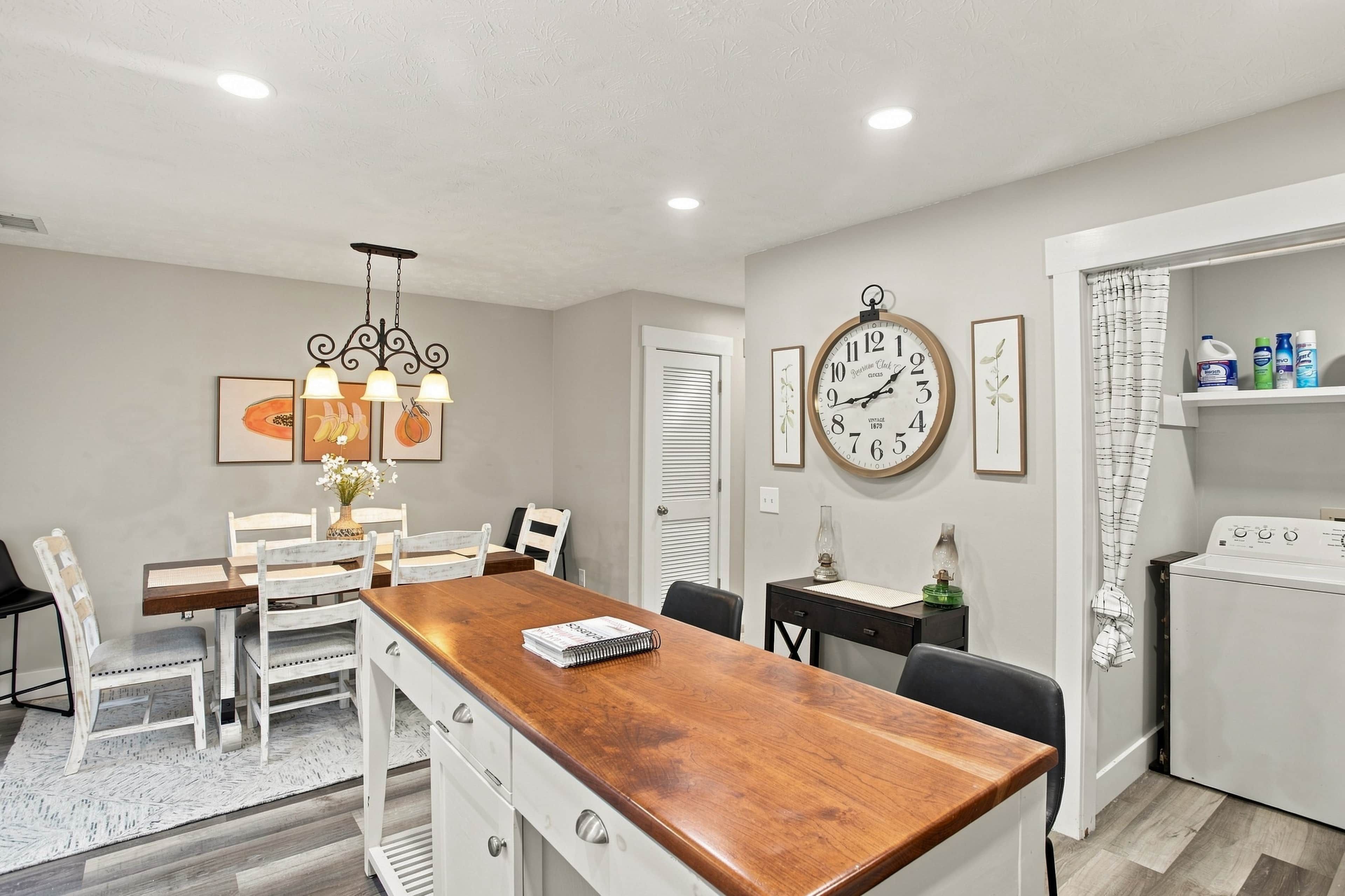A dining area with a wooden table, chairs, and a chandelier.