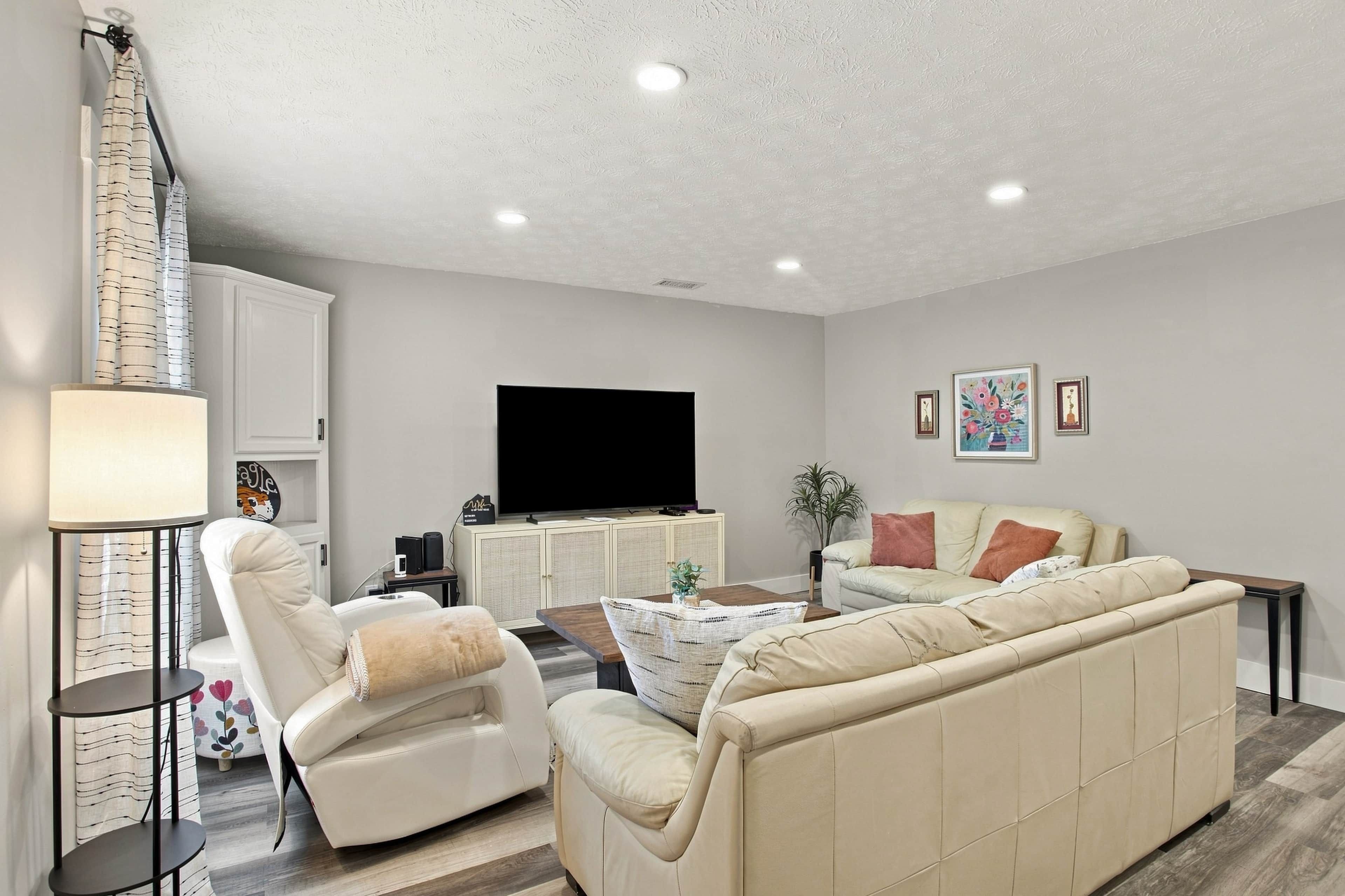 A living room with a flat-screen TV, two sofas, a coffee table, and a lamp.