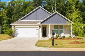 Een woonhuis met twee verdiepingen, een garage, een voortuin en een brievenbus.