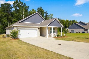A two-story residential building with a garage, a covered porch, and a well-maintained lawn. - The Loveliest Stay in Auburn (Auburn)
