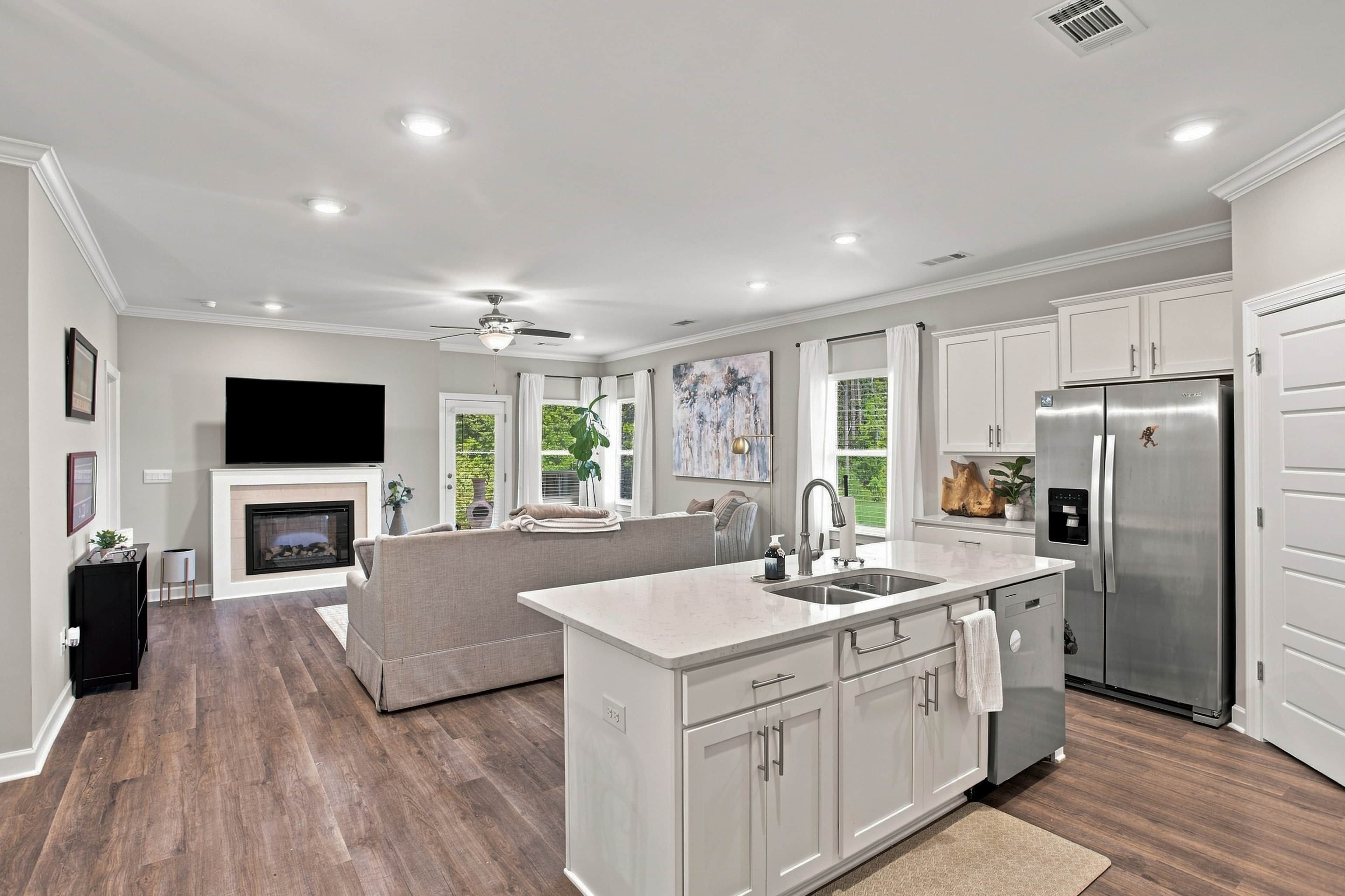 A modern kitchen with a central island, stainless steel appliances, and a fireplace.