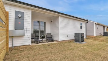 Une maison mobile de plain-pied dotée d’un patio couvert, d’une grande fenêtre et d’un coffret de raccordement.