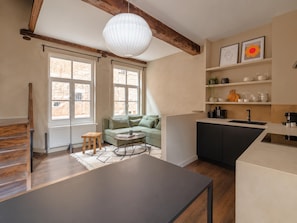 A modern kitchen with a dining area, large windows, and a loft-style ceiling. - Le Sablon Hideaway Charming House in the Heart of Brussels (Brussels)