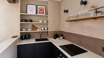 A modern kitchen with black cabinets, a white countertop, and a built-in oven.