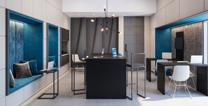 Een modern interieur met een zwarte tafel in het midden, zithoeken met blauwe kussens en een flatscreentelevisie aan de rechterkant.