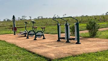 Outdoor exercise equipment in a park with a dirt path and grass.