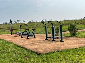 Outdoor exercise equipment in a park with a dirt path and grass.