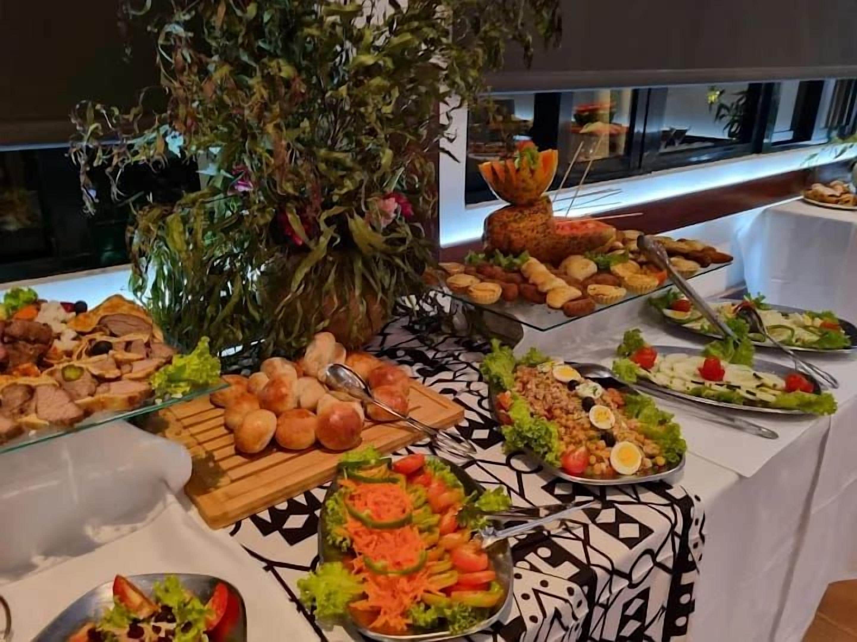 Una mesa de buffet con diferentes alimentos y una planta decorativa.