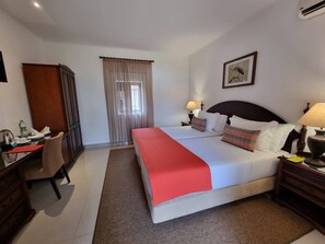 Una habitación de hotel con cama, mesitas de noche, escritorio y armario.