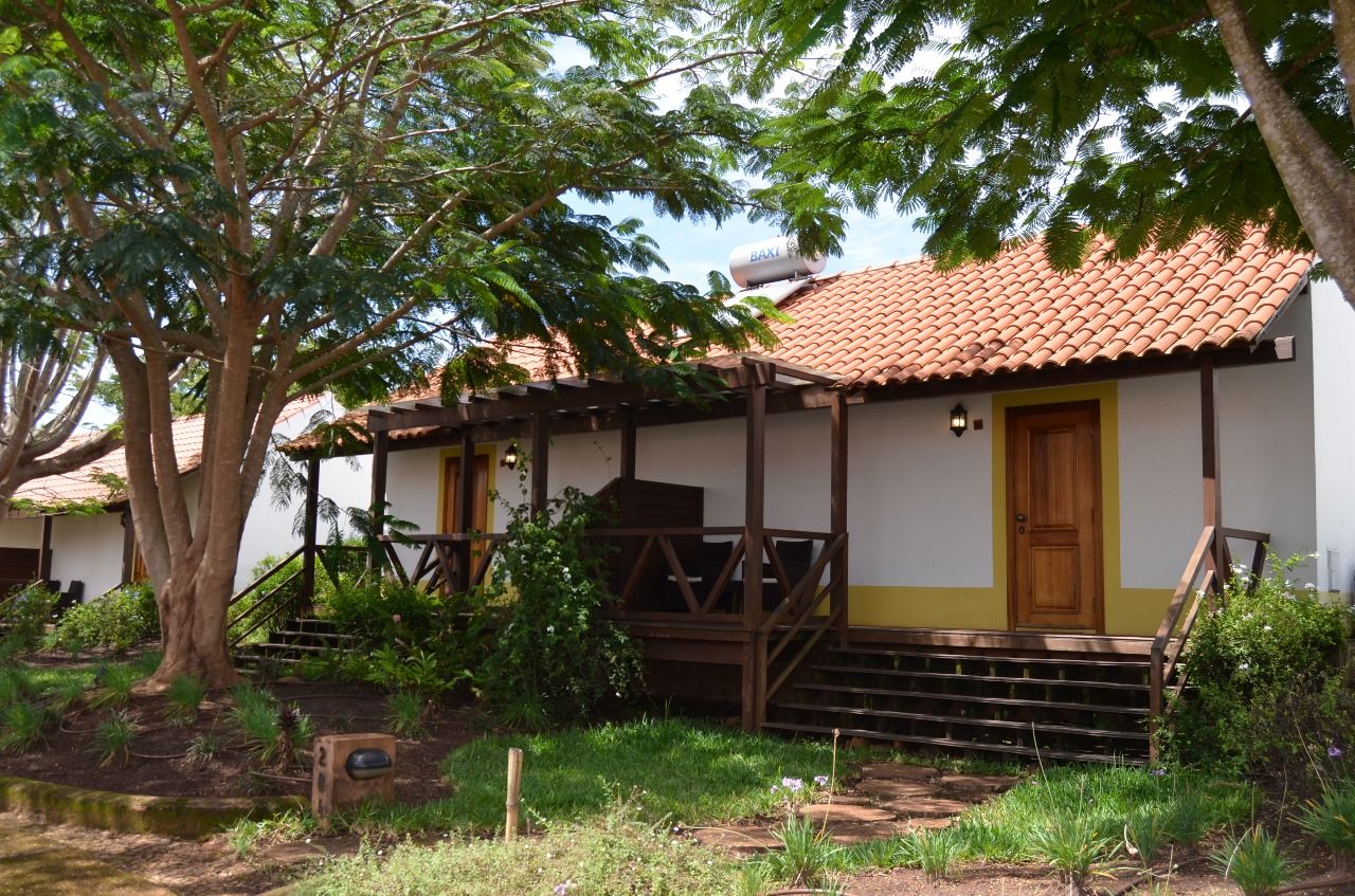 A building with a tiled roof, a wooden porch, and a yellow door.