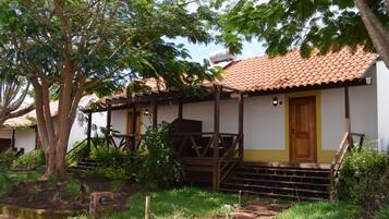 A building with a tiled roof, a wooden porch, and a yellow door.