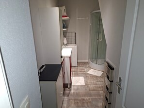 Une petite salle de bain comprenant une douche, des toilettes et un lavabo.