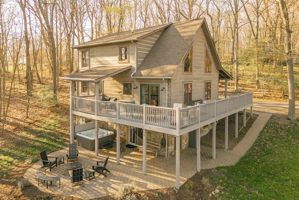 A two-story house with a deck and outdoor seating area.