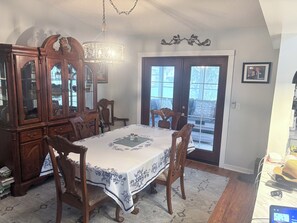 A dining room with a wooden table, chairs, a chandelier, and a large cabinet. - Adjacent to The Villages Property (Summerfield)