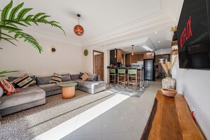 Una sala de estar moderna con un sofá, una mesa de centro y una cocina al fondo.