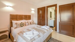 Ein Schlafzimmer mit Bett, Nachttisch, Kleiderschrank und angrenzendem Badezimmer.
