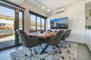Una sala de reunions moderna amb una taula gran, cadires còmodes i un quadre de paisatge urbà a la paret.