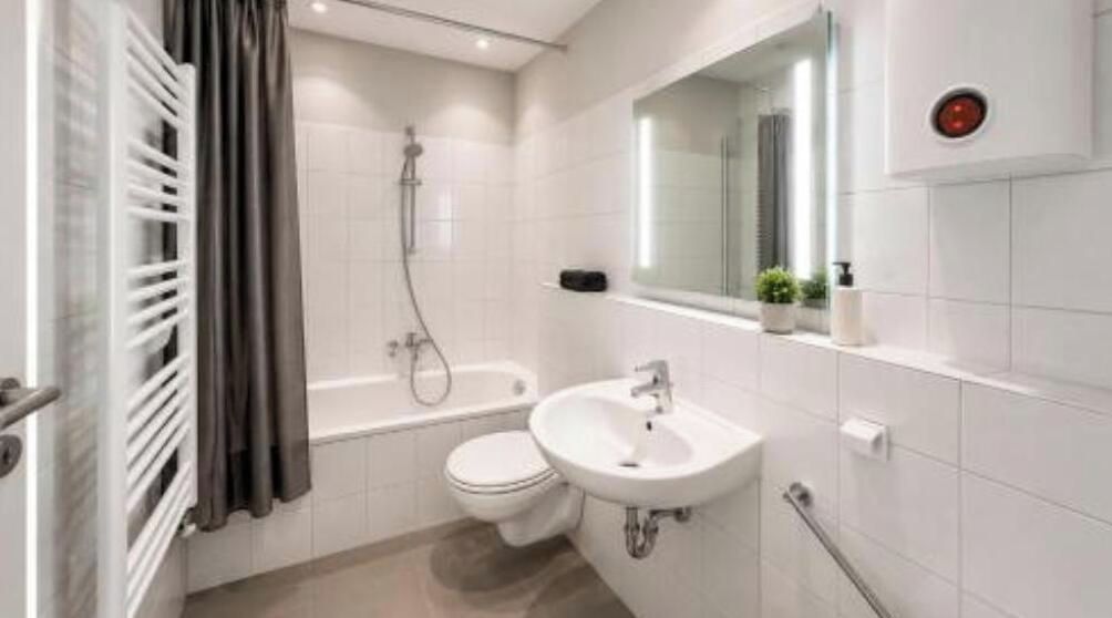 Ein modernes Badezimmer mit Badewanne, Toilette und Waschbecken.