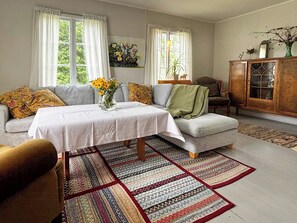 Una sala de estar con sofá, mesa y aparador.