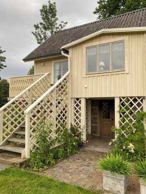 A two-story house with a wooden staircase and a front door. - Farmhouse with tiled stoves near lake and forest (Asarum)