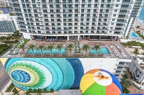 A multi-story hotel with a pool area, outdoor seating, and a view of the ocean. - 40th Floor Ocean Penthouses Together (Hollywood)