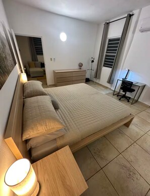 A bedroom with a bed, bedside tables, a desk, and a lamp. - El Yunque Sunset Mountain Villa • Private Pool (Canóvanas)