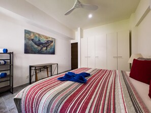 Ein Hotelzimmer mit Bett, einem Gemälde, einem Schreibtisch und einem Kleiderschrank.
