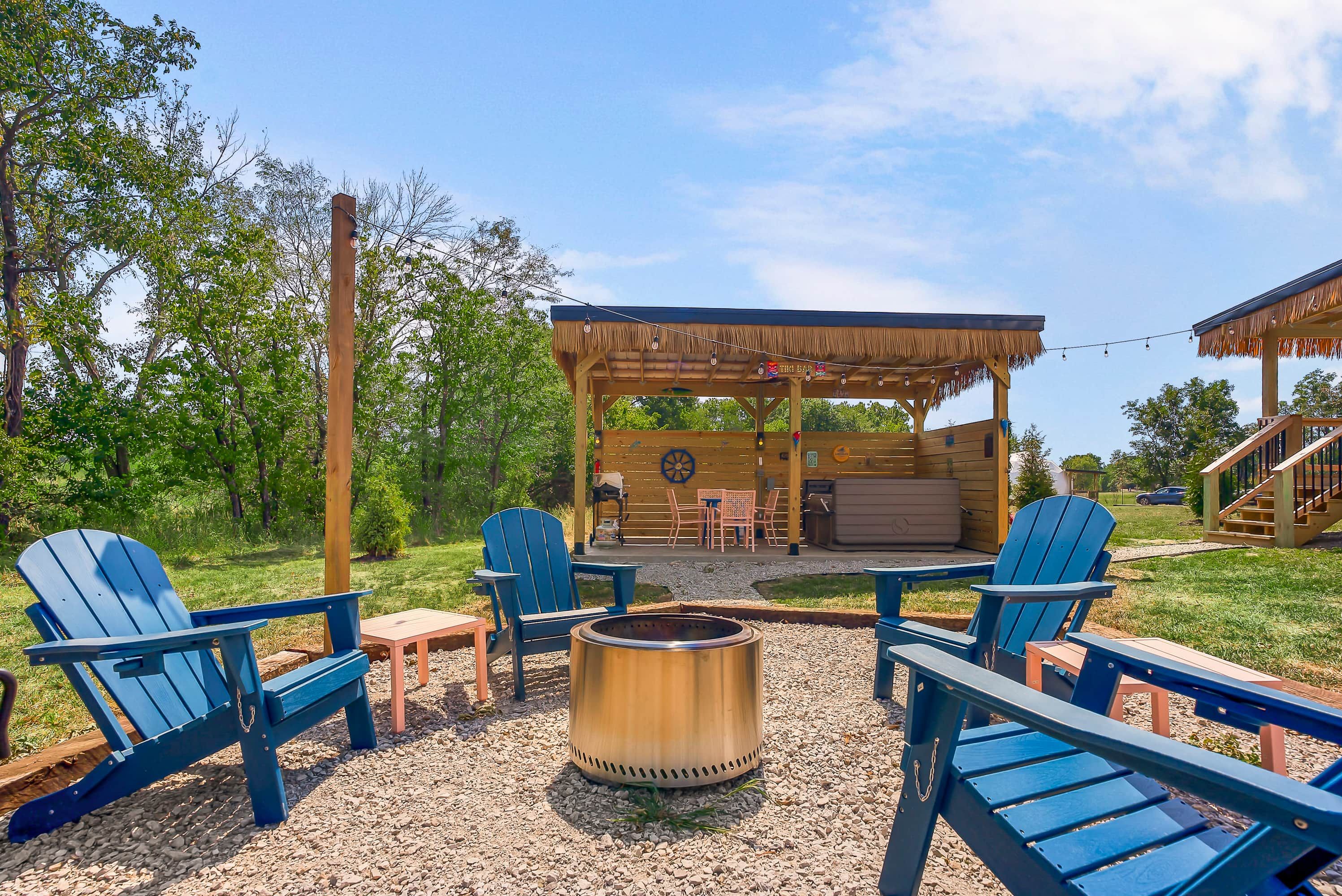 Una terraza de madera con mobiliario exterior, una chimenea y un espacio cubierto con mesas y sillas.