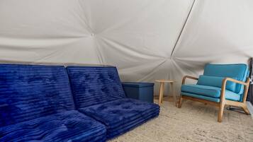 Een tent met een blauwe bank en een blauwe stoel binnen.