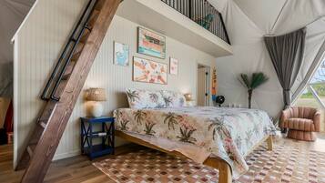 Een slaapkamer met een bed, nachtkastje, lamp, stoel en raam.