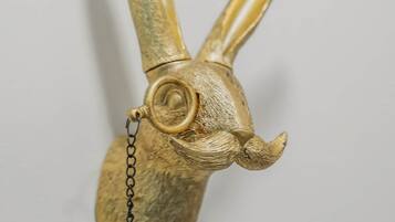 A gold-colored, textured object resembling a head with horns, attached to a chain.