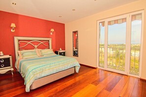 A bedroom with a bed, nightstands, a mirror, and a large window with a view. - CT 233 - 1001 Nights - 1001 Nights - CT 233 (Benalmadena)