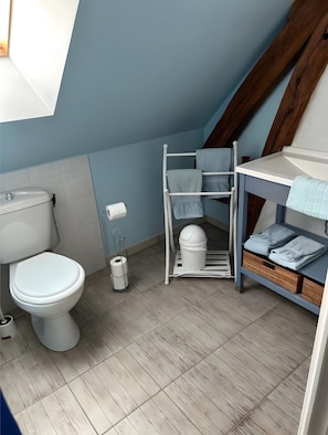A compact bathroom with a toilet, a sink, and a towel rack.