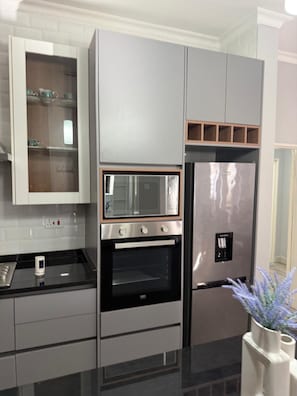 Una cocina moderna con electrodomésticos integrados, incluyendo un microondas, horno y refrigerador.