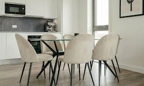 A modern kitchen with white cabinets, a built-in microwave, and a coffee machine. - Modern 2-Bed Greenwich Apartment Fast Links to Canary Wharf (London)