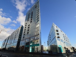 En moderne bygning med en glasfacade og tydelig indgang.