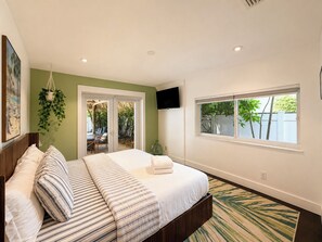 A bedroom with a bed, a TV, a window, and a view of the outdoors. - ★★★★★4BD/3BA VILLA.CLOSE TO THE OCEAN.HEATED POOL! (Hollywood)