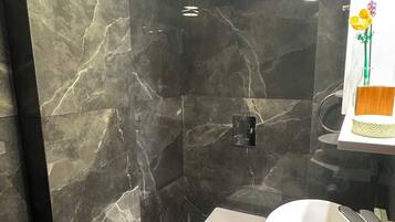Un baño moderno con inodoro, lavamanos y zona de ducha.
