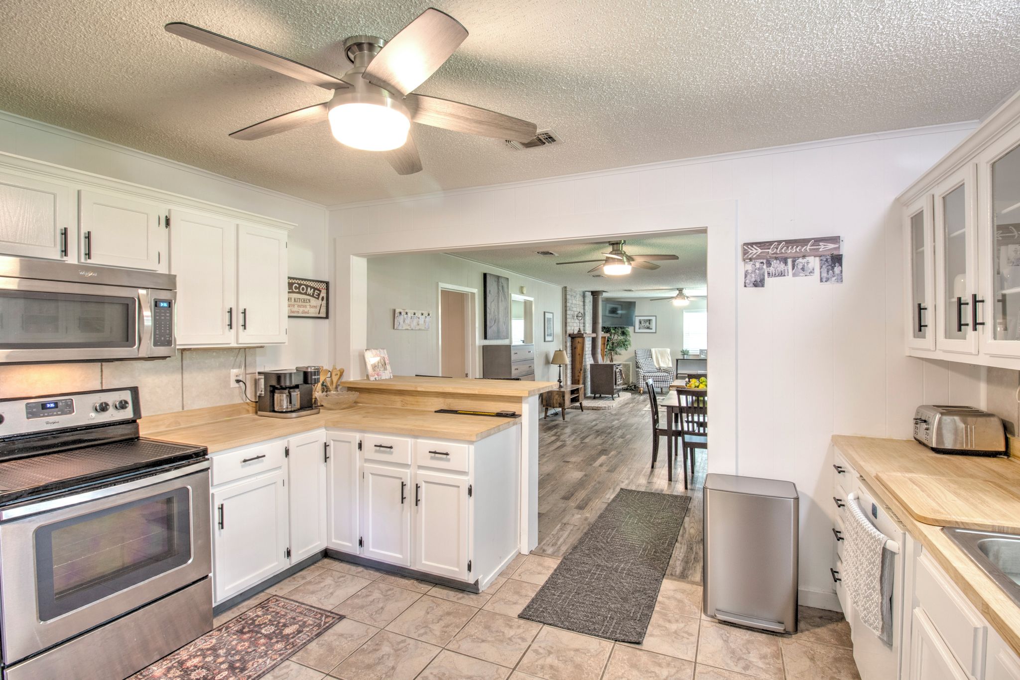A modern kitchen with white cabinetry, stainless steel appliances, and a central island.