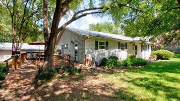A single-story house with a front porch, a covered patio area, and a well-maintained lawn.