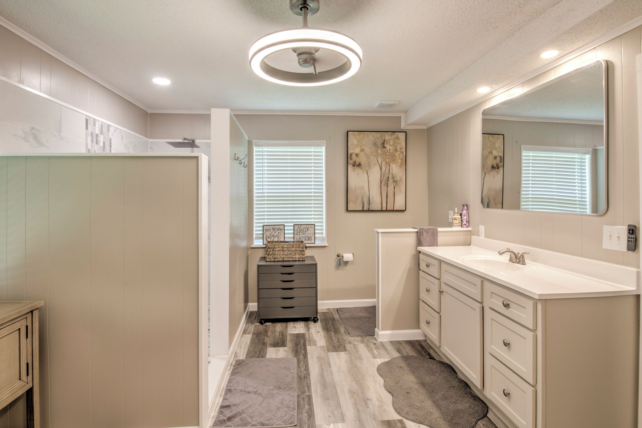 A bathroom with a vanity, a mirror, a towel rack, and a ceiling light fixture.