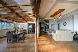 Un amplio salón con techo de madera, un comedor y un sofá.