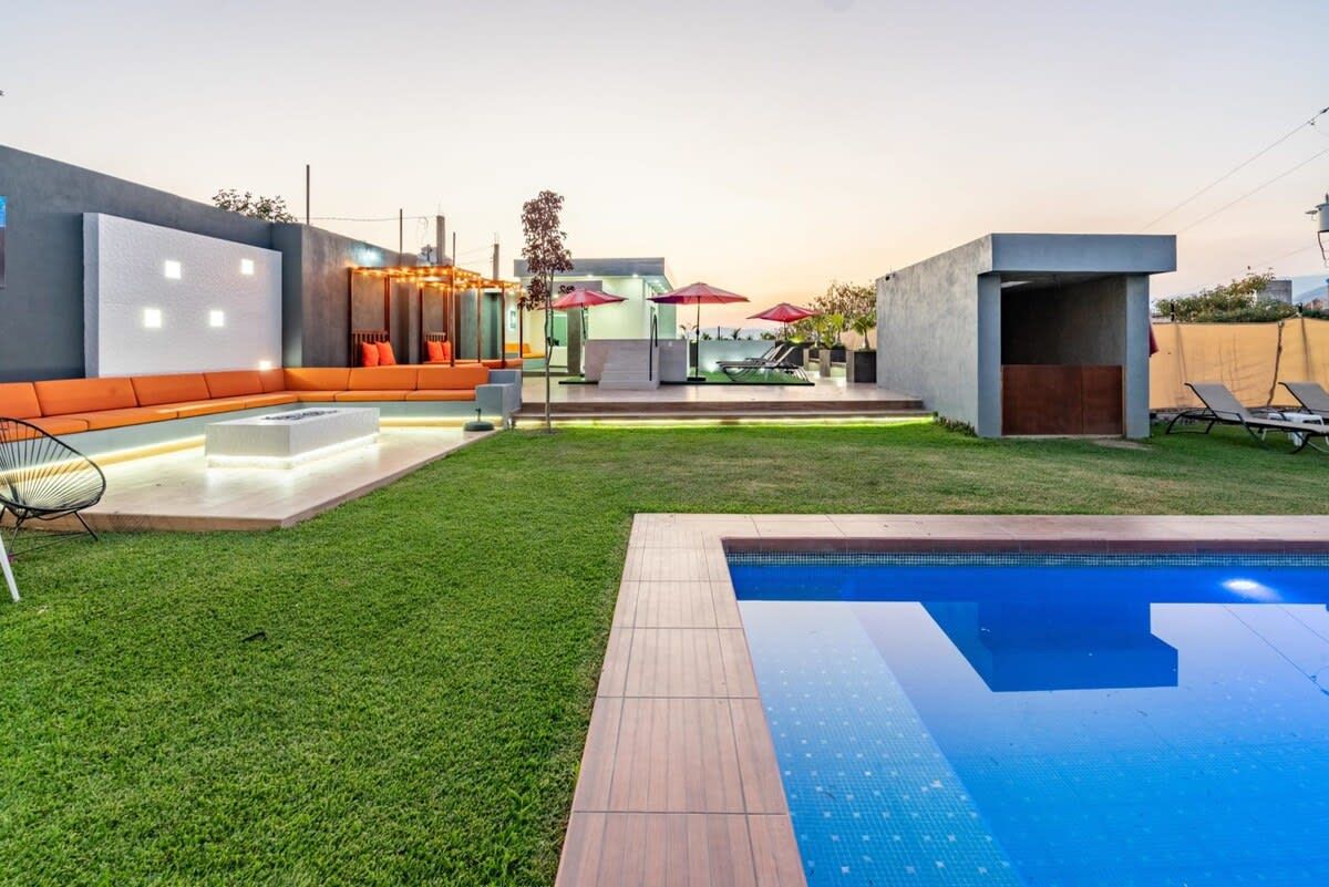 Een modern zwembad met een ingebouwd zitgedeelte en een aparte lounge met parasols.