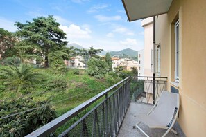 A balcony with a view of a residential area, a mountain, and a fence. - Casa Andrea - Two Bedroom Apartment, Sleeps 4 (Arenzano)