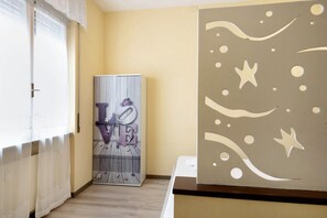 Ein Zimmer mit Heizkörper, einem LOVE-Schild und einer Wand mit kreis- und sternförmigen Ausschnitten.