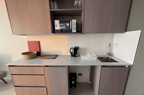Eine moderne Küche mit integriertem Mikrowellenherd, einer Kaffeemaschine und einem Spülbecken.