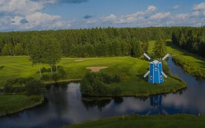 A windmill on a grassy island surrounded by water and trees. - Room with 2 Queen Beds (ST PAMPHILE)